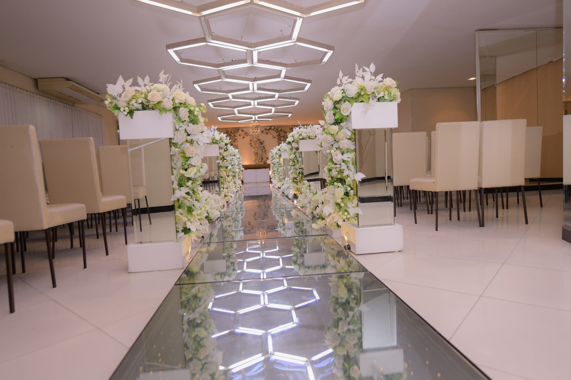 Arcos florais brancos formando o caminho até o altar do Salão Cerimonial