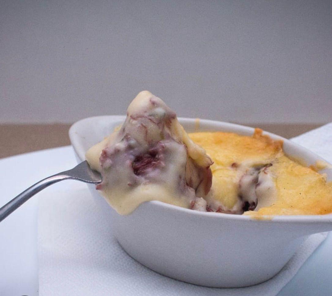 Escondidinho gratinado servido na colher, com purê dourado e recheio de carne com queijo derretido