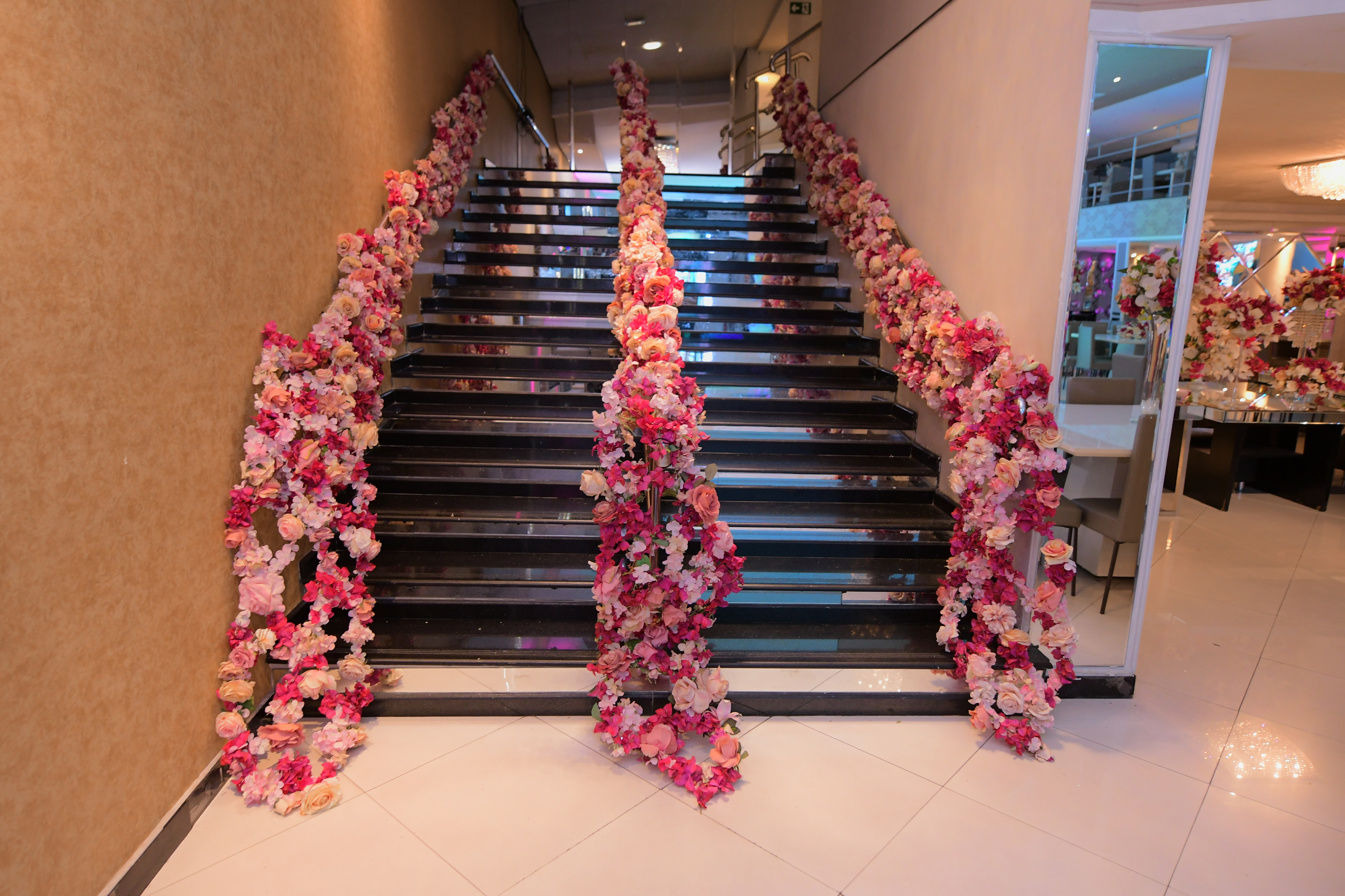 Escada de vidro do San Pelegrine decorada com guirlandas de rosas em tons de rosa