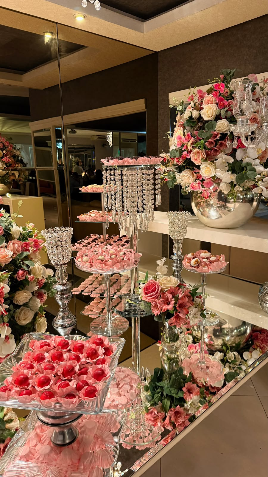 Mesa de doces finos do Salão Perrie com bandejas de cristal e arranjos florais em tons de rosa